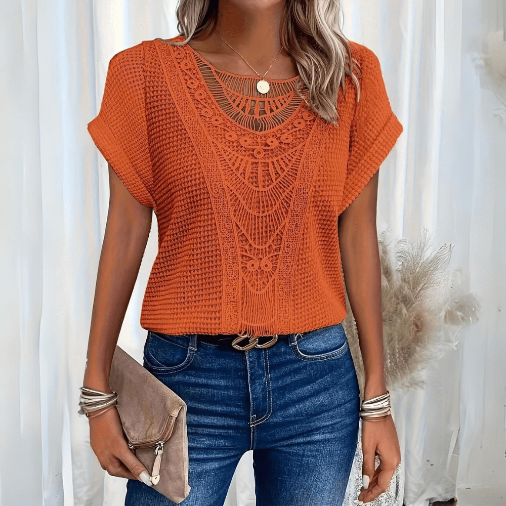 Woman wearing a relaxed waffle-knit top with an open crochet panel down the front and rolled cap sleeves