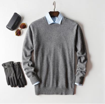 Men's plain knit crew neck sweater layered over a collared shirt