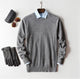 Men's plain knit crew neck sweater layered over a collared shirt