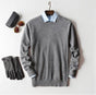 Men's plain knit crew neck sweater layered over a collared shirt