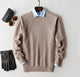 Men's plain knit crew neck sweater layered over a collared shirt