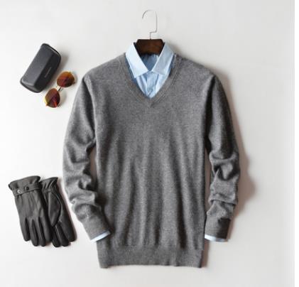 Men's plain knit crew neck sweater layered over a collared shirt