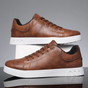 Men's low-top lace-up sneaker with stitched panels and white flat sole