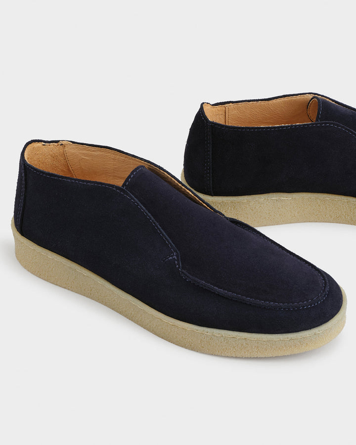 Men's navy moc toe ankle boots with slip-on opening and flat contrasting soles