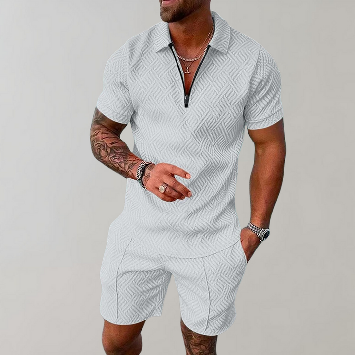 Man wearing a quarter-zip short-sleeve polo in a textured geometric knit with matching shorts