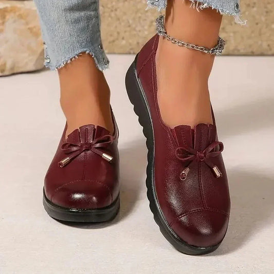 Women's round-toe moccasin loafers with bow detail and flat scalloped soles
