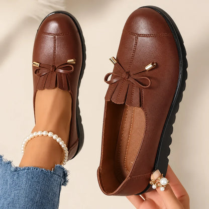 Women's round-toe moccasin loafers with bow detail and flat scalloped soles