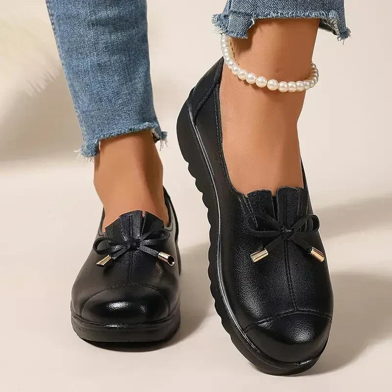 Women's round-toe moccasin loafers with bow detail and flat scalloped soles
