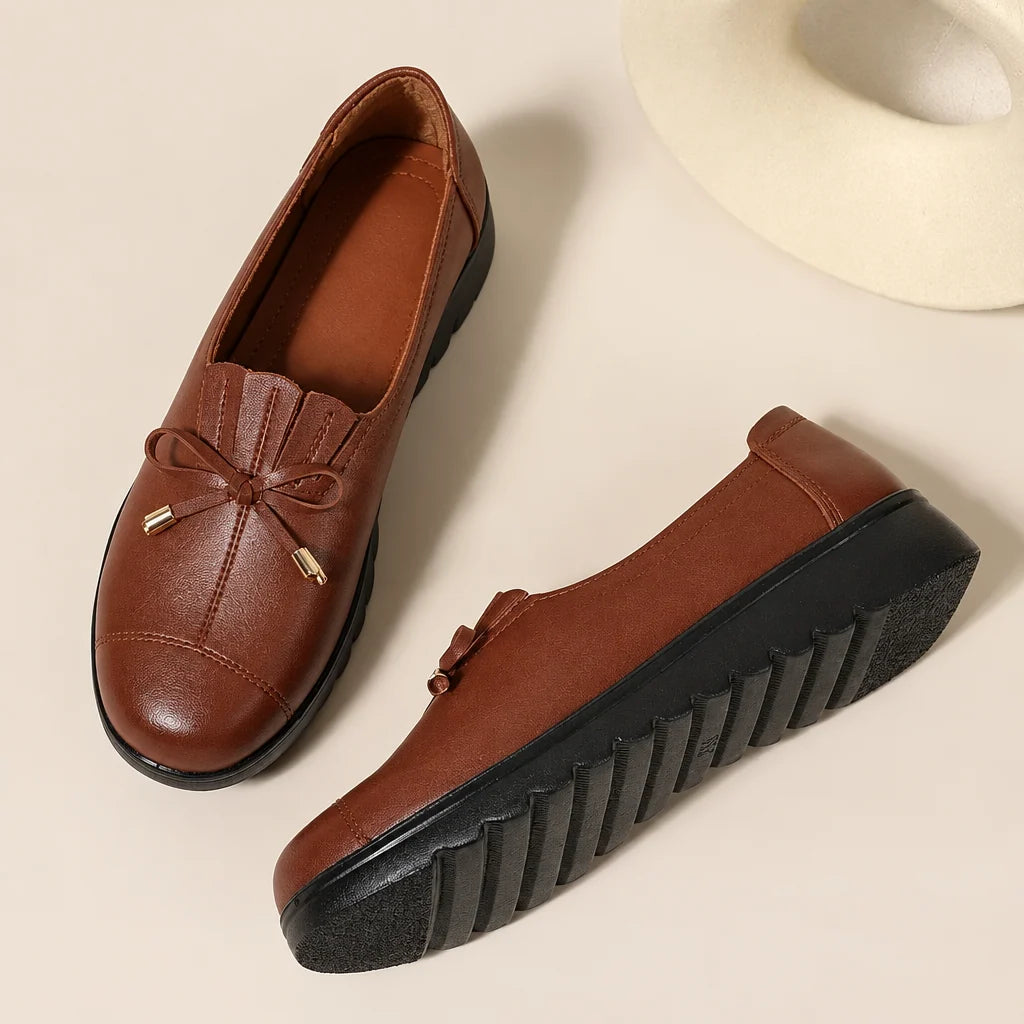 Women's round-toe moccasin loafers with bow detail and flat scalloped soles