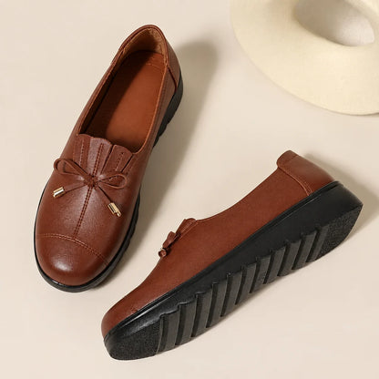 Women's round-toe moccasin loafers with bow detail and flat scalloped soles
