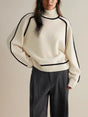 Women's oversized turtleneck sweater with contrast piping and long sleeves