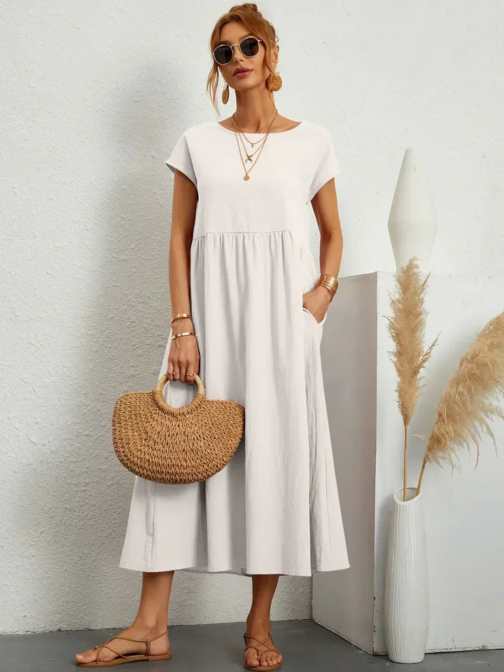 Women's flowing midi dress with round neck and short sleeves, shown in white and navy