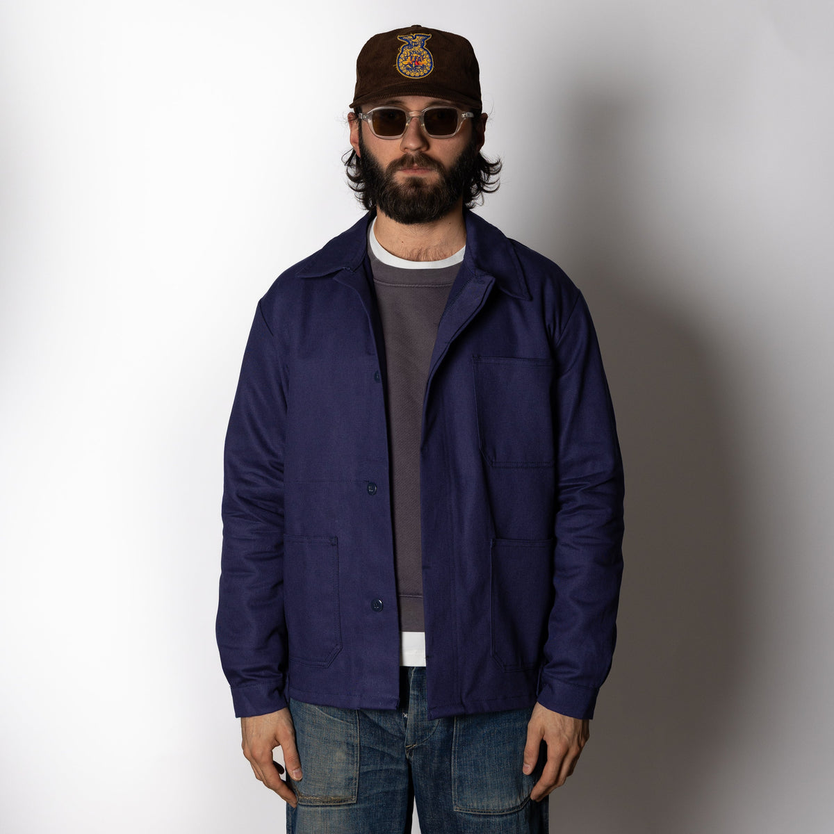 Men's navy chore jacket with button front, pointed collar and four patch pockets
