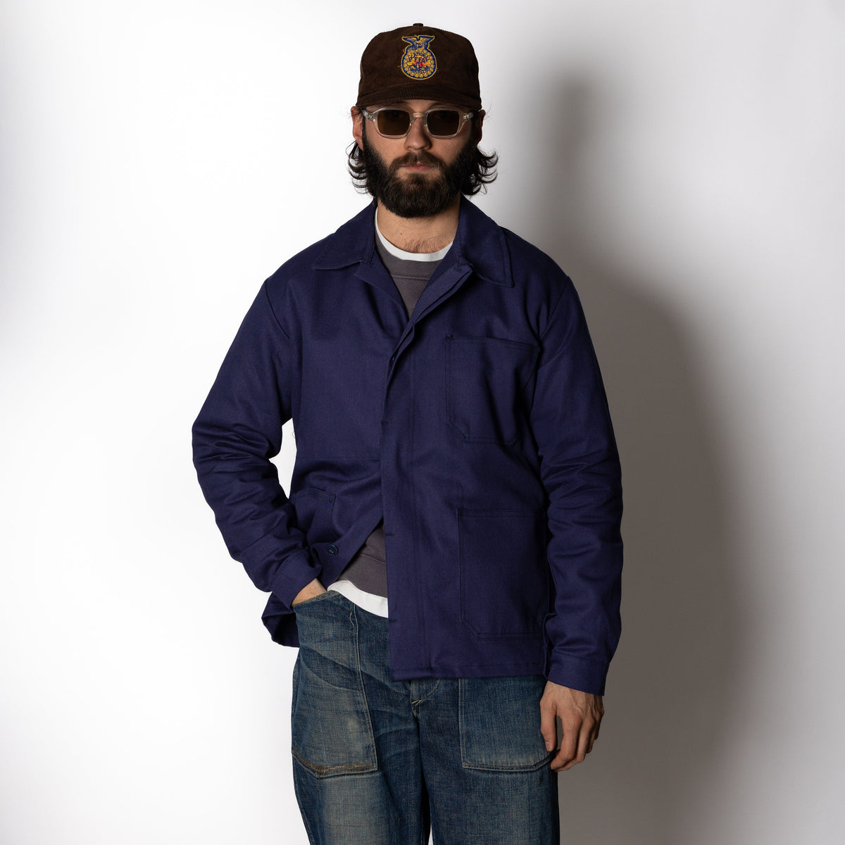 Men's navy chore jacket with button front, pointed collar and four patch pockets