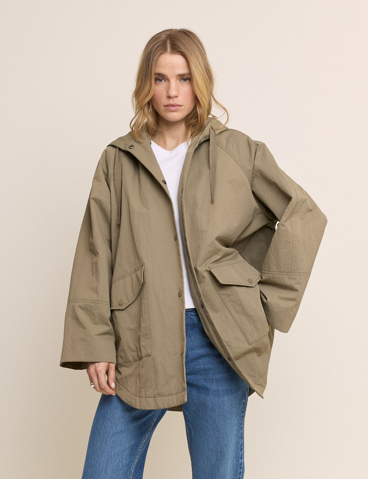 Women's olive green hooded parka jacket with long sleeves and utility pockets
