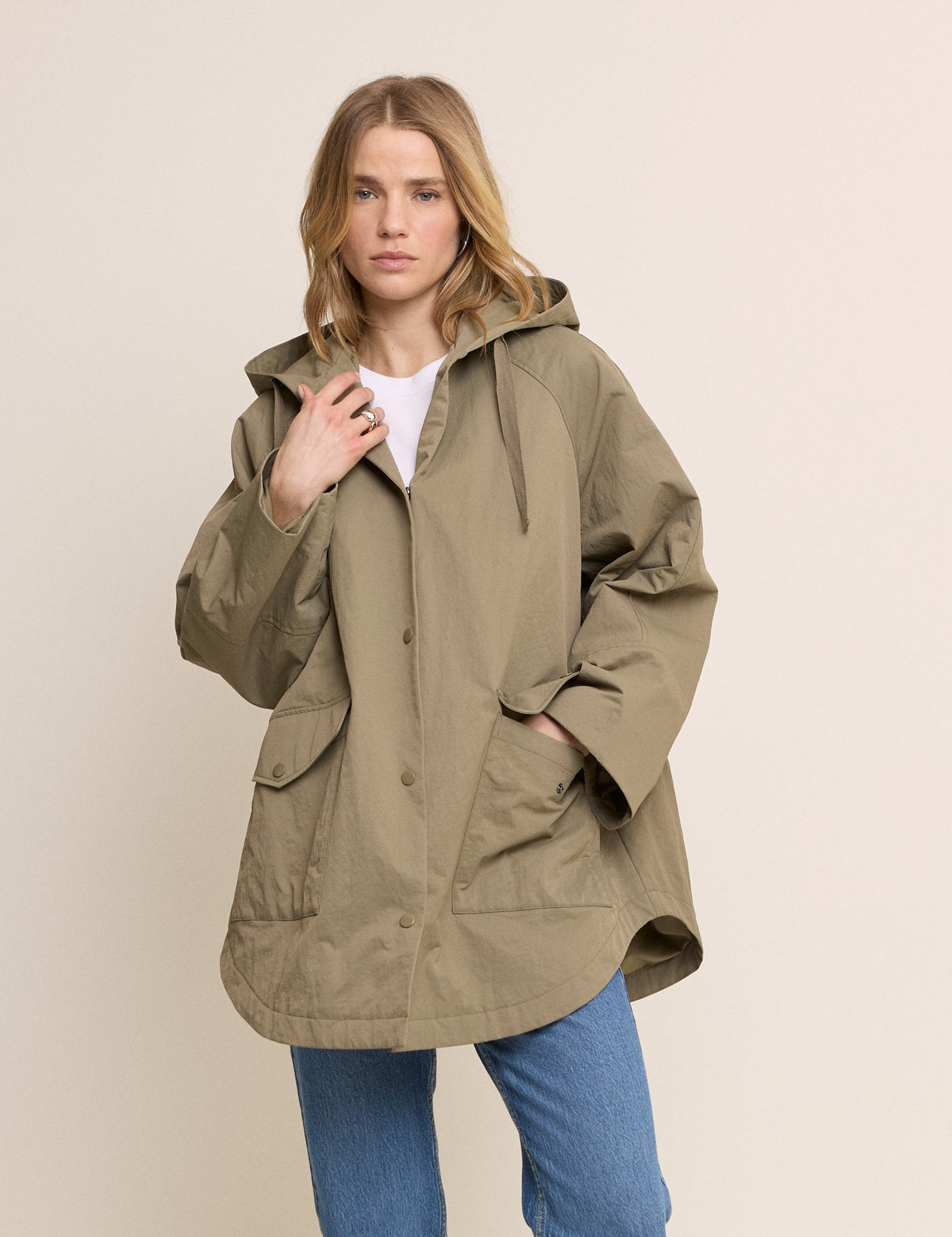 Women's olive green hooded parka jacket with long sleeves and utility pockets