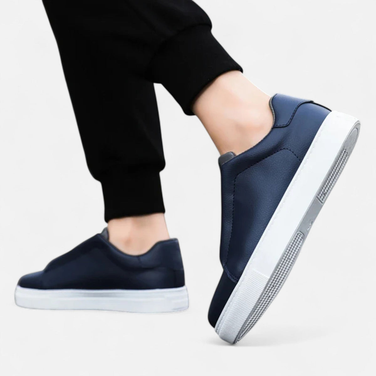Men's low-top slip-on sneakers with stitched panels and flat white soles