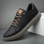Men's low-top lace-up sneakers with stitched panels and a layered flat sole