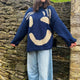 Women's oversized knit sweater with a large smiley face graphic