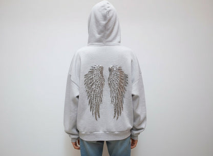 Women's gray hoodie with drawstring hood and silver sequin wings on the back