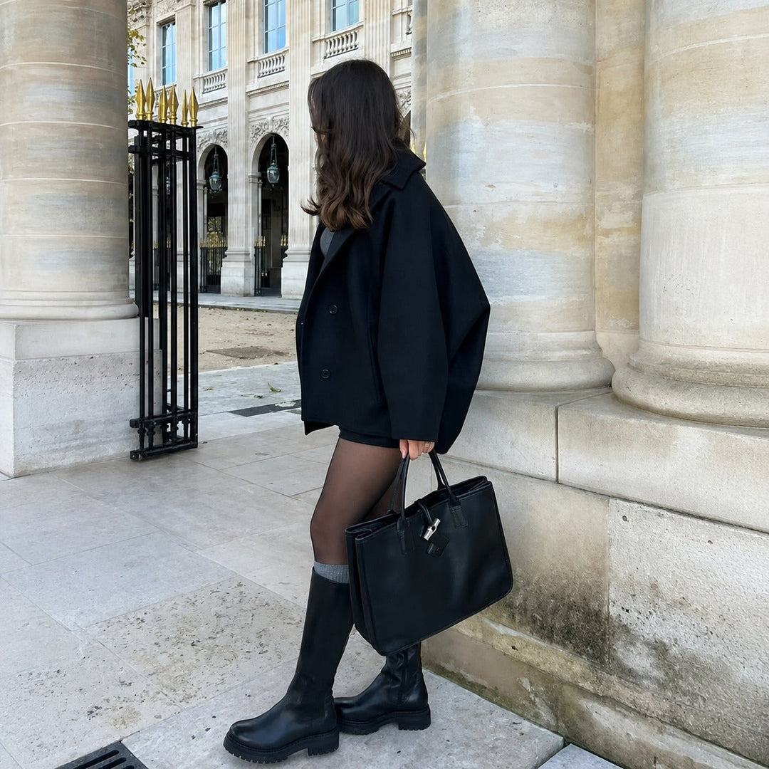 Woman wearing an oversized short coat with notched lapels, long sleeves and front pockets