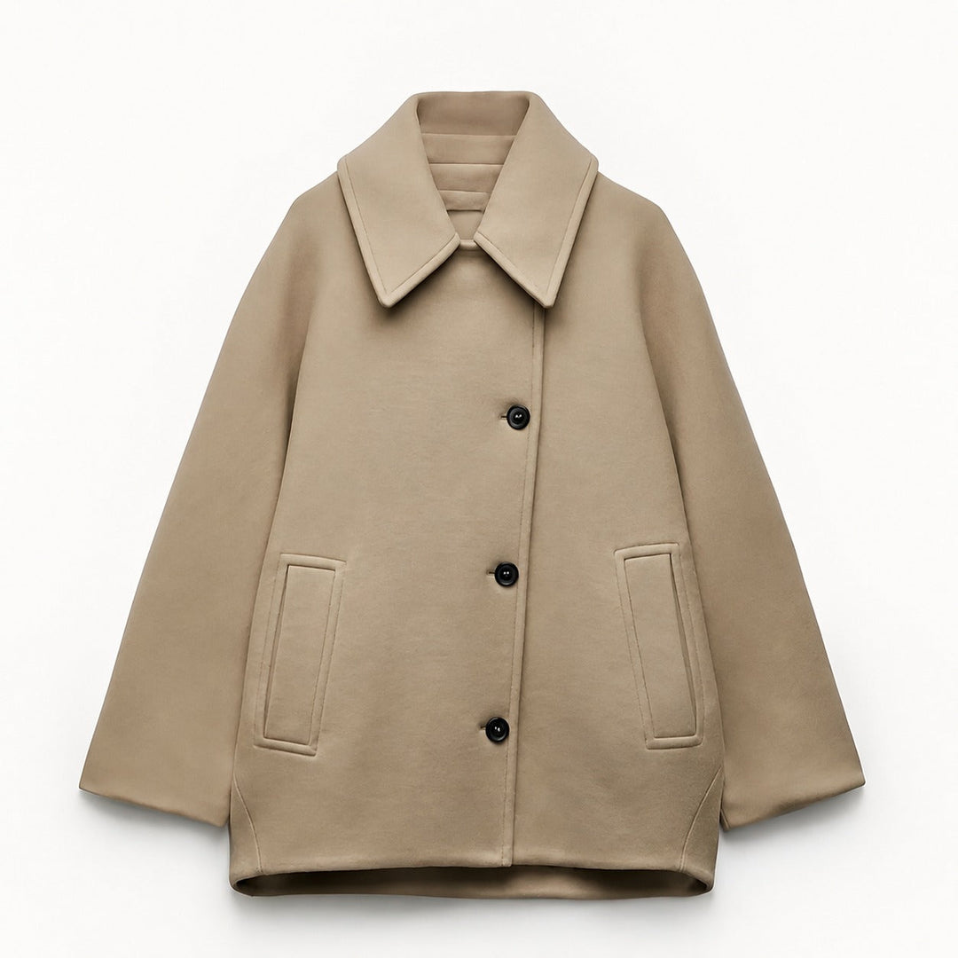 Woman wearing an oversized short coat with notched lapels, long sleeves and front pockets