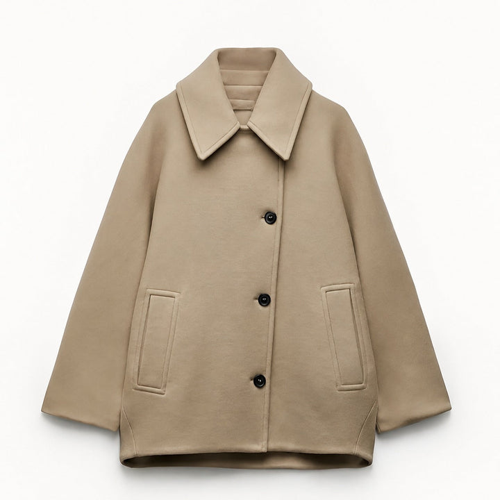 Woman wearing an oversized short coat with notched lapels, long sleeves and front pockets