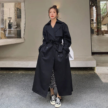 Women's full-length belted trench coat with wide lapels and buckle cuffs