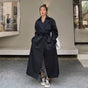 Women's full-length belted trench coat with wide lapels and buckle cuffs