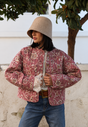 Women's pink floral quilted jacket with button front and piped trims