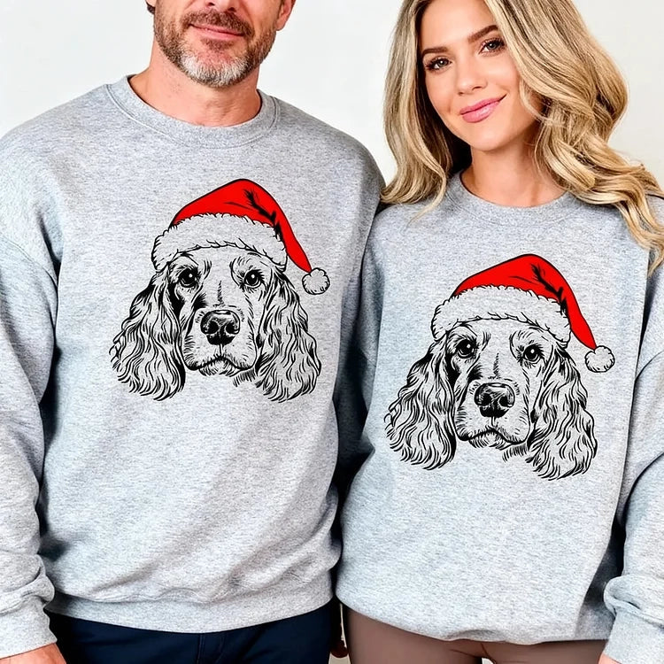 Unisex grey Christmas sweatshirt with dog Santa hat design, shown on family members around decorated kitchen