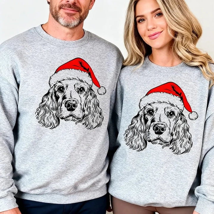Unisex grey Christmas sweatshirt with dog Santa hat design, shown on family members around decorated kitchen