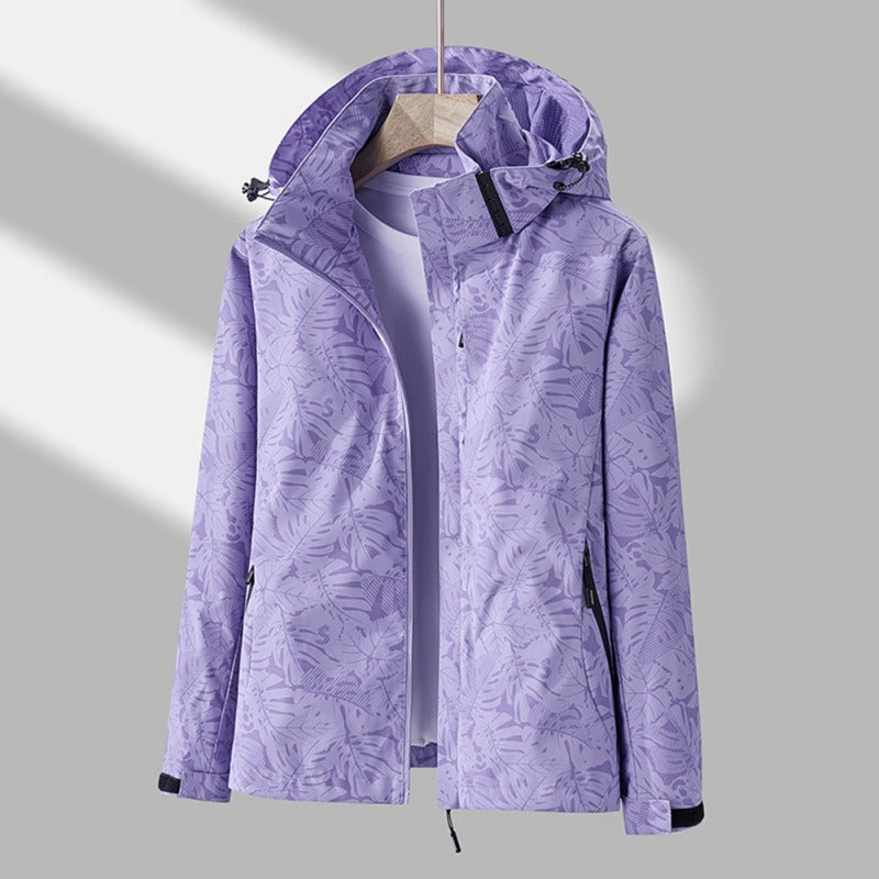 Women's hooded leaf print rain jacket with long sleeves and zipped pockets