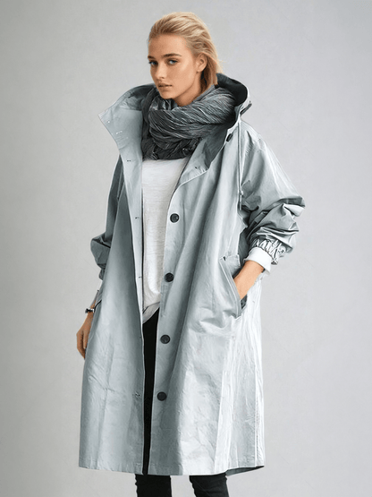 Woman wearing a longline hooded button-front trench coat with patch pockets