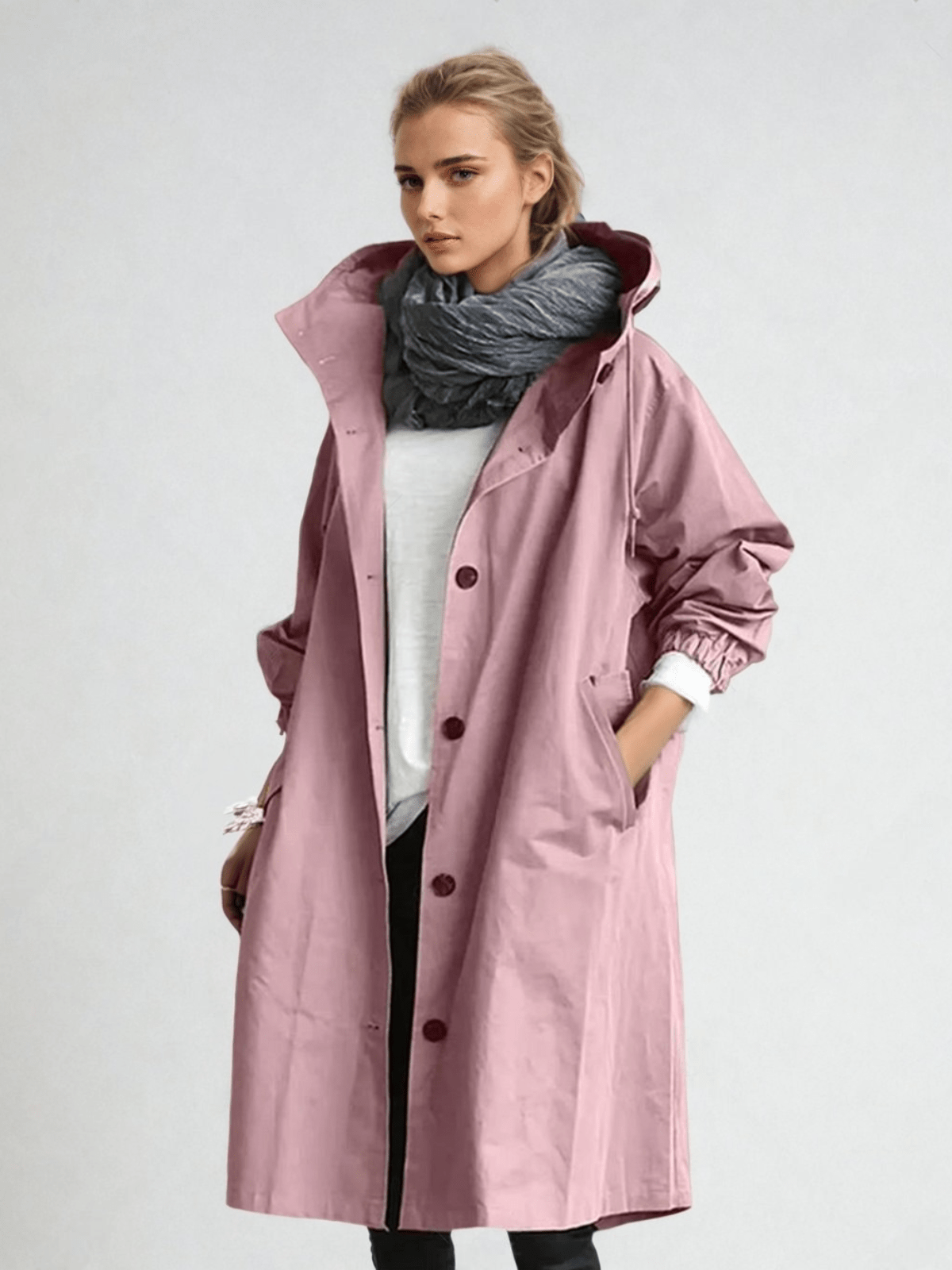 Woman wearing a longline hooded button-front trench coat with patch pockets