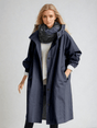 Woman wearing a longline hooded button-front trench coat with patch pockets