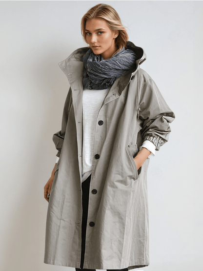Woman wearing a longline hooded button-front trench coat with patch pockets