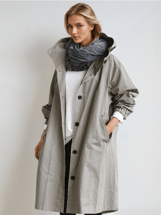 Woman wearing a longline hooded button-front trench coat with patch pockets