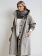 Woman wearing a longline hooded button-front trench coat with patch pockets