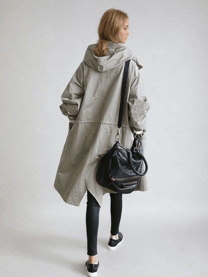 Woman wearing a longline hooded button-front trench coat with patch pockets