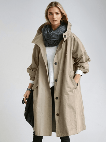 Woman wearing a longline hooded button-front trench coat with patch pockets