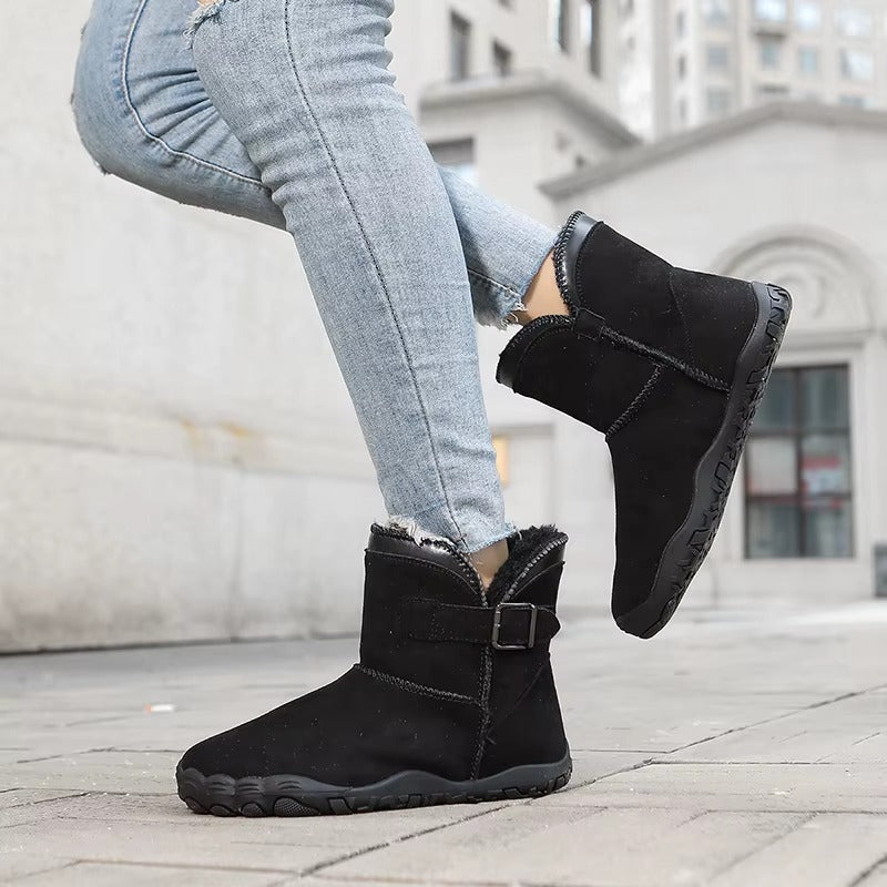 Ankle-height barefoot winter boots with faux fur lining, buckle strap and textured tread