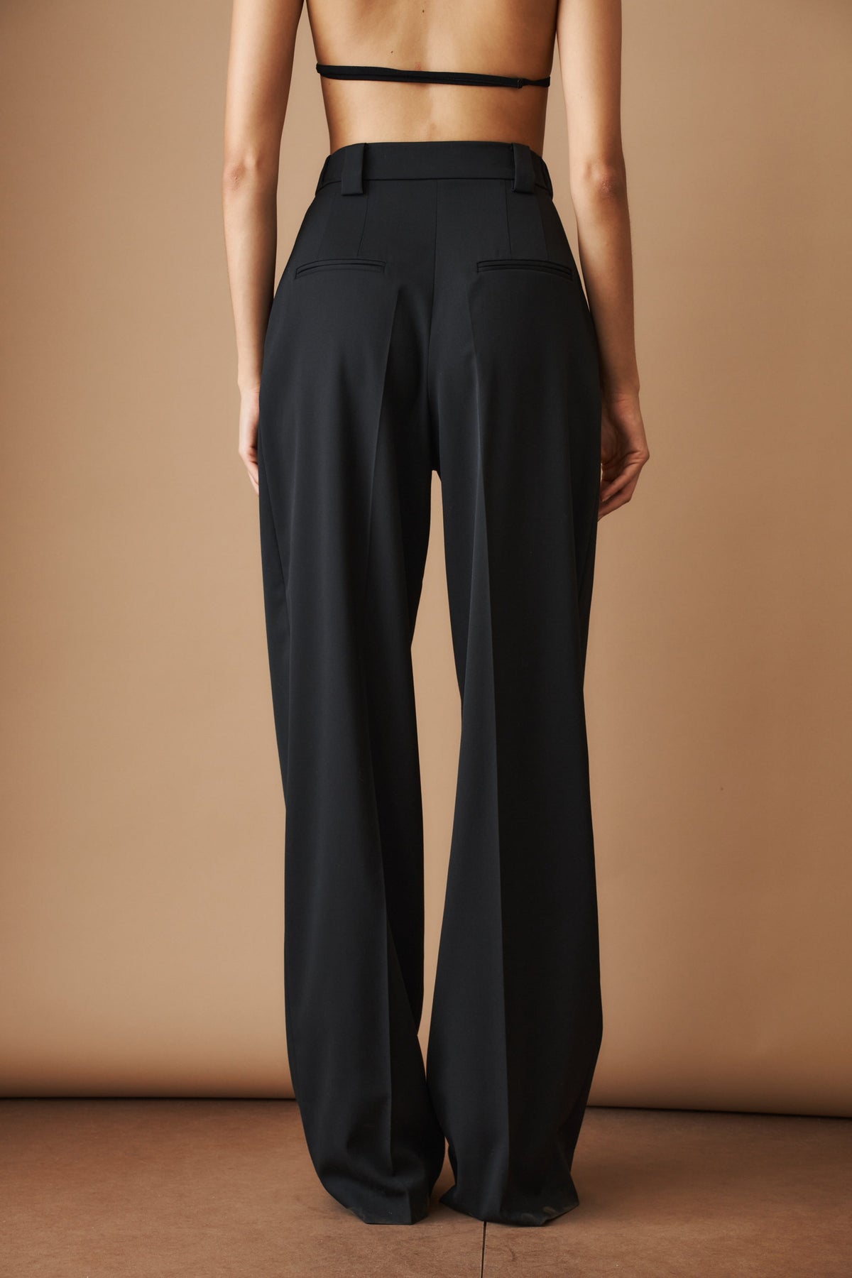 Women's black high-waisted wide-leg pleated pants with belt loops and side pockets