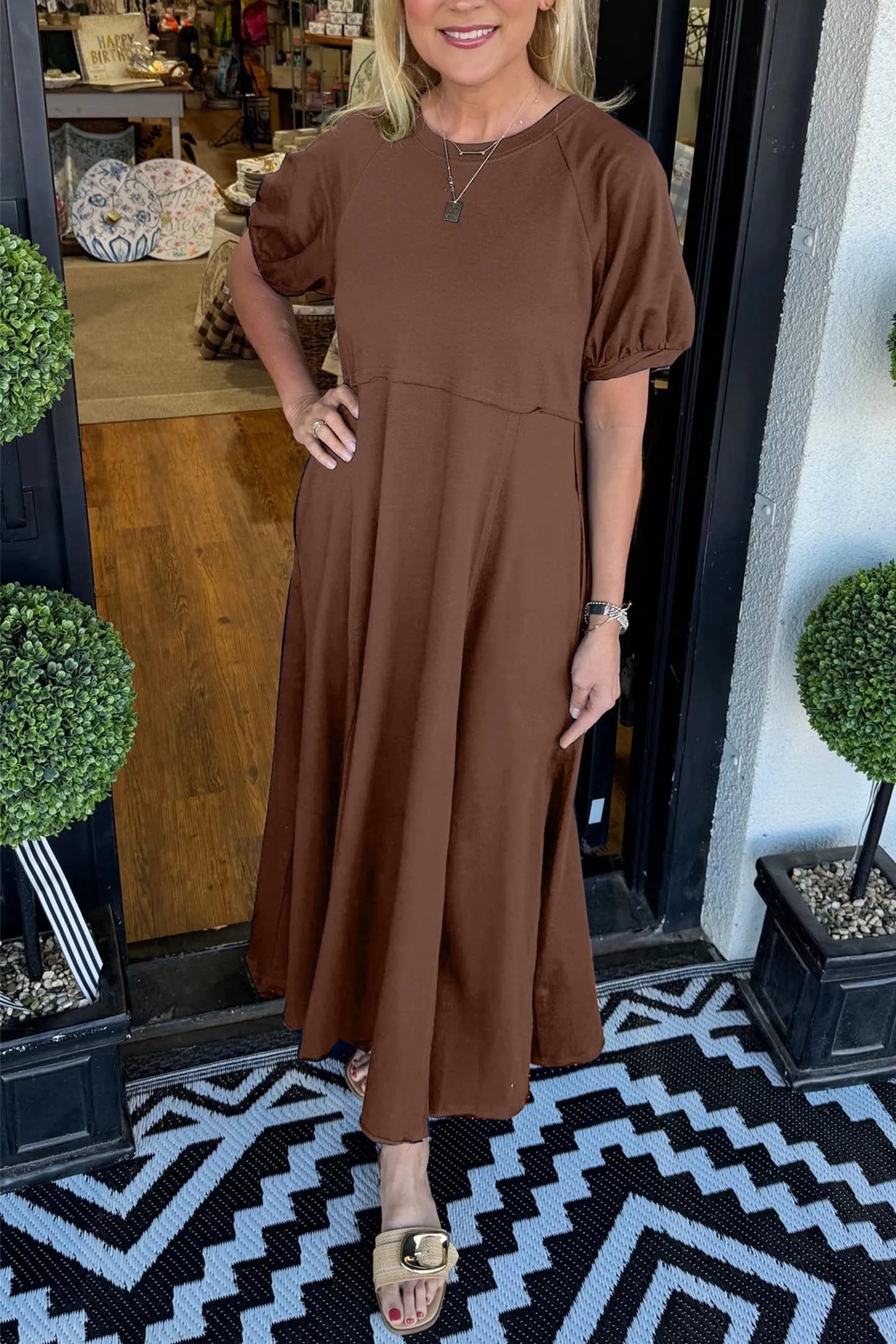 A model casually strolling in the navy puff sleeve maxi dress, showcasing its relaxed fit and movement.