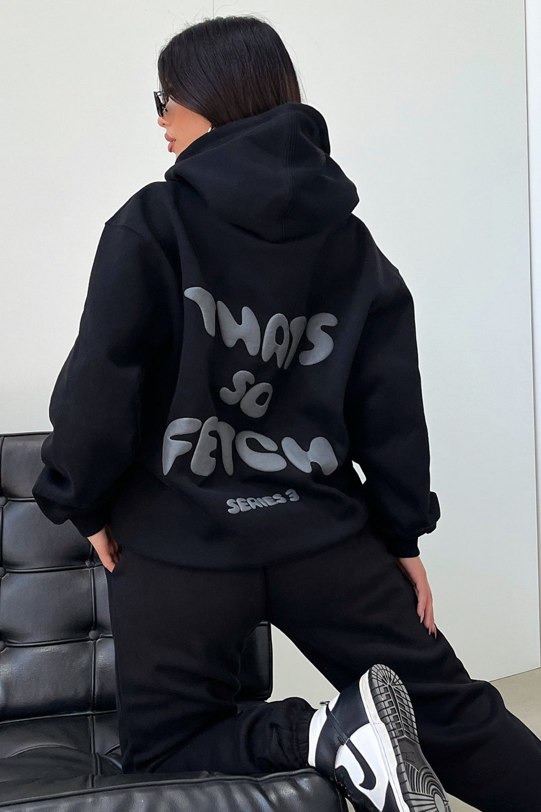 Women's black cropped hoodie with hood, long sleeves and contrasting back graphic text