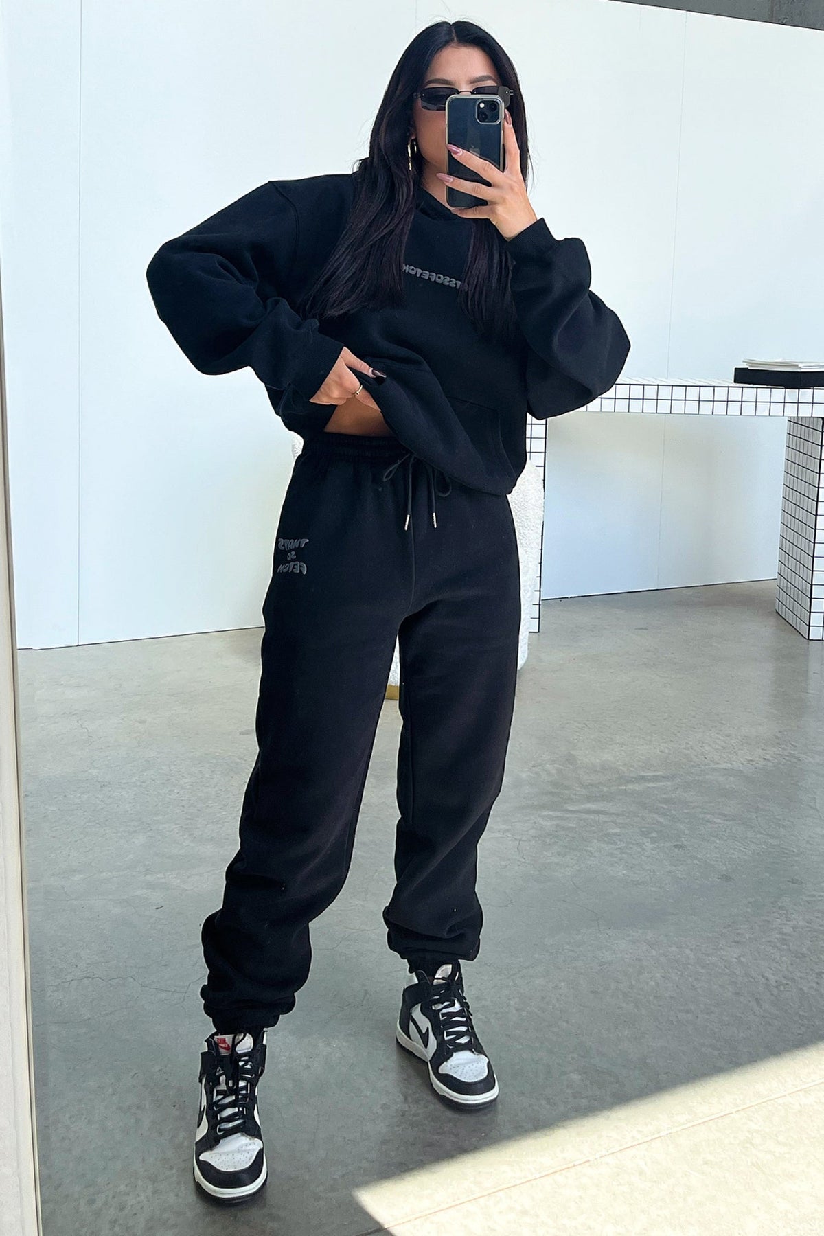 Women's black cropped hoodie with hood, long sleeves and contrasting back graphic text