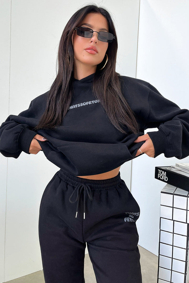Women's black cropped hoodie with hood, long sleeves and contrasting back graphic text