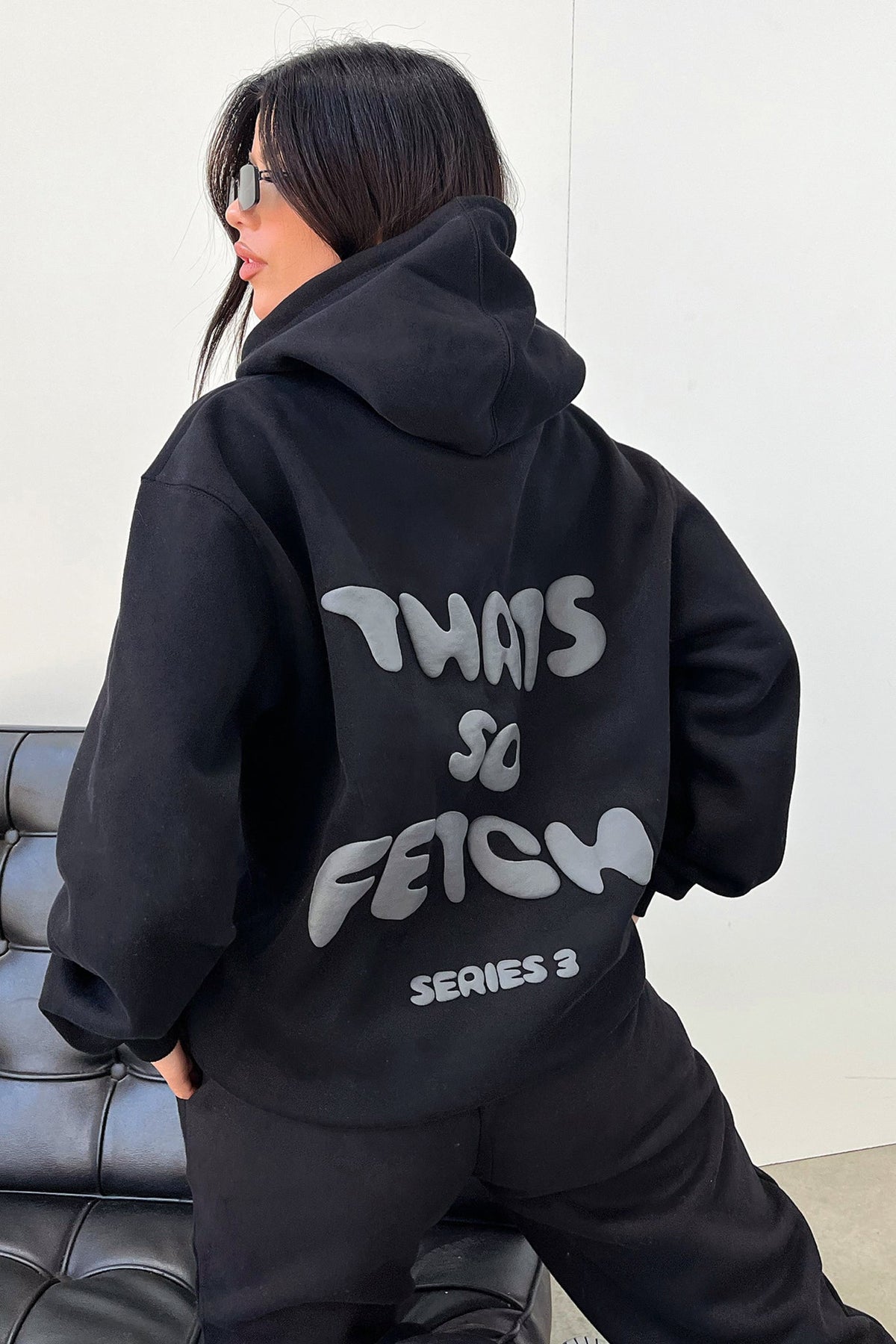 Women's black cropped hoodie with hood, long sleeves and contrasting back graphic text