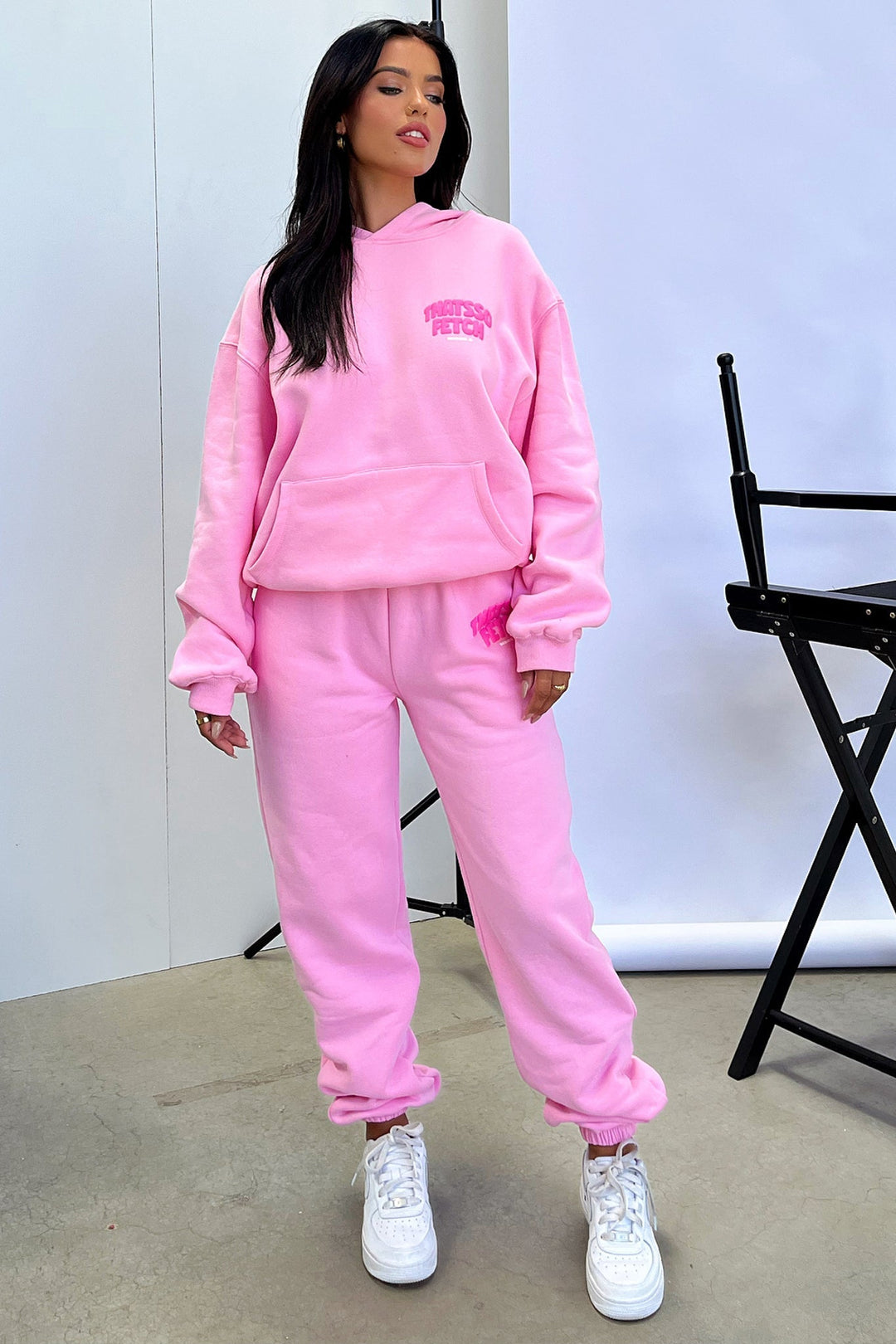 Women's pink cropped hoodie with long sleeves, front pouch pocket and chest text detail