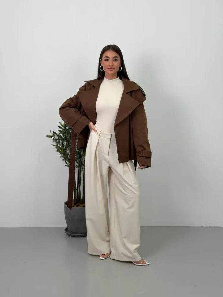 Women's brown cropped trench coat with wide lapels and tie belt